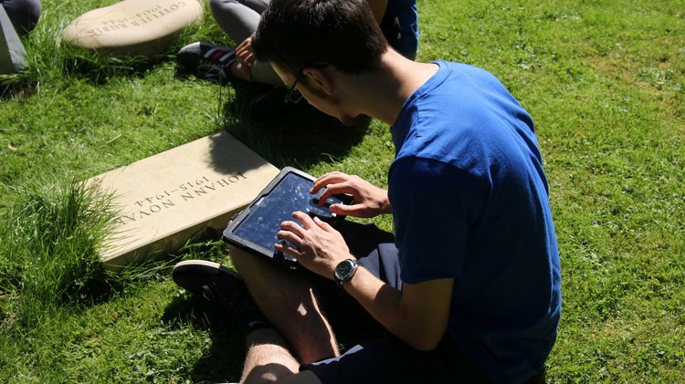 Teilnehmer während der Durchführung des Bildungsmoduls "Mit dem Tablet in die Vergangenheit" auf dem Hauptfriedhof Kassel